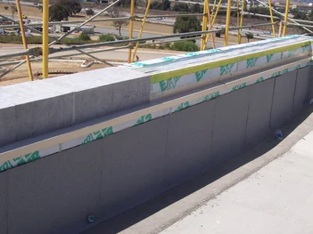 Tremco ExoAir self-adhered membrane is shown applied to the foundation of a structure to prevent air and water leaks.