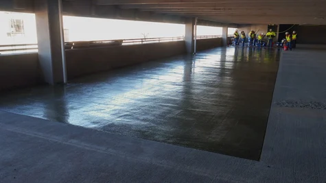 A newly applied waterproof PMMA/PUMA coating is displayed within the interior of a concrete parking garage.