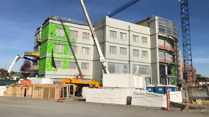 A partially finished structure shown with Tremco air barrier material applied to the exterior façade.