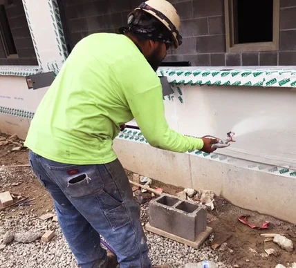 A worker applying a Tremco sprayable air barrier solution onto an exterior above-grade wall assembly.