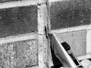 A utility knife is used to cut out a small strip of installed sealant as part of a Field Adhesion Test.