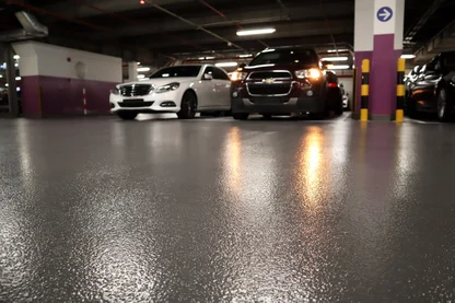 Concrete flooring of a parking garage structure treated with waterproofing coating to prevent cracking and deterioration.