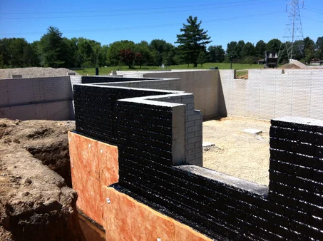 A view of a below-grade foundation wall treated with TREMproof exterior waterproof membrane.