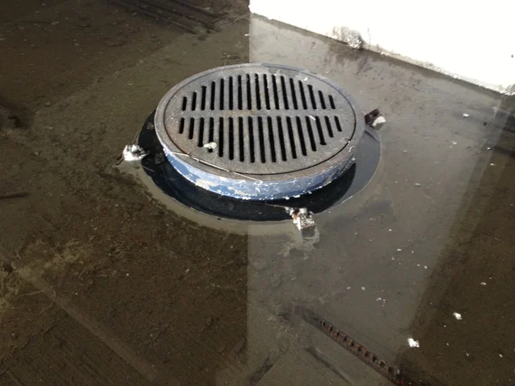 An example of a drain sitting too high above the level of the concrete surface likely due to improper waterproofing application resulting in ponding.