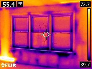 A thermal heat map shows areas of temperature difference where cooler air-conditioned interior air is leaking outside.