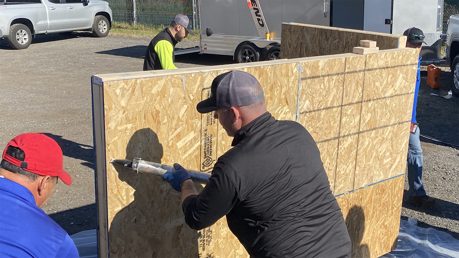 Installer applying sealant outside on a wall mockup