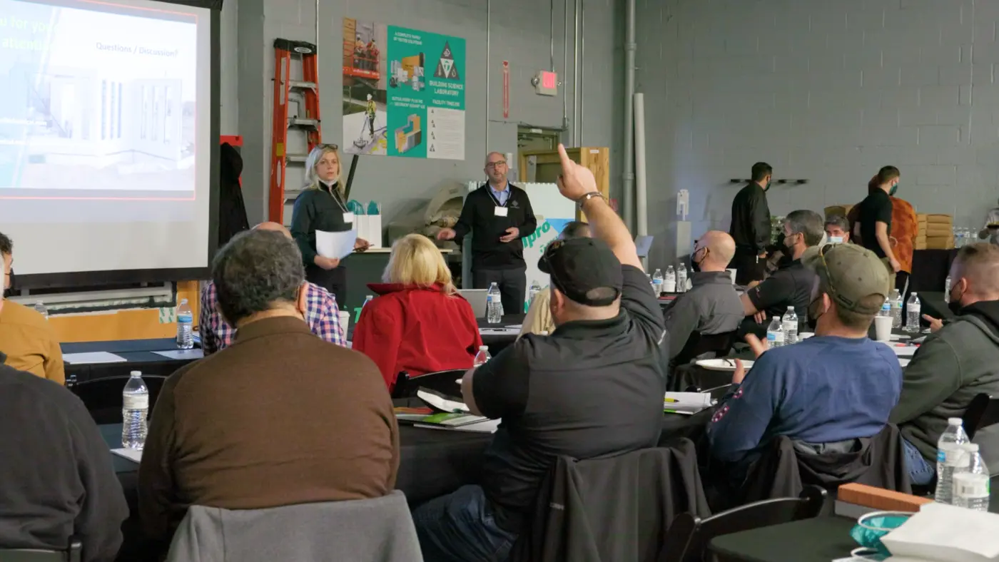 group in an architectural presentation with someone raising their hand